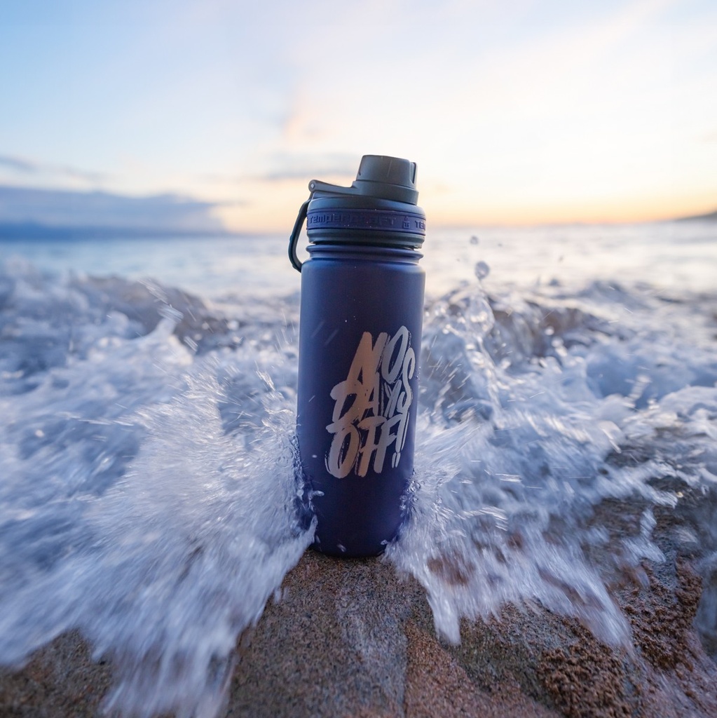 Laser engraved navy 18 oz Tempercraft Sport Bottle on the beach