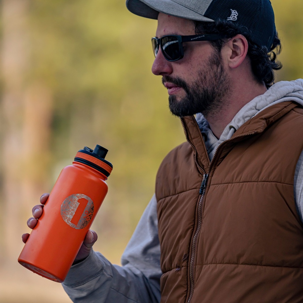 Laser engraved orange 32 oz Tempercraft Sport Bottle outdoors
