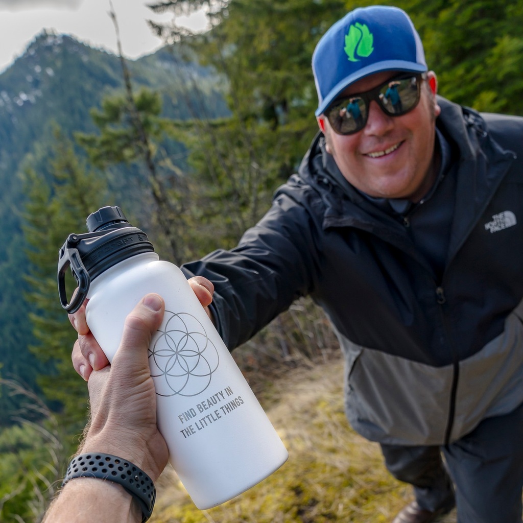 Laser engraved white 32 oz Tempercraft Sport Bottle on the trail